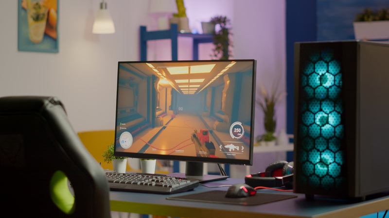 Cosy games room lit with neon and RGB lighting, gaming chair and PC setup