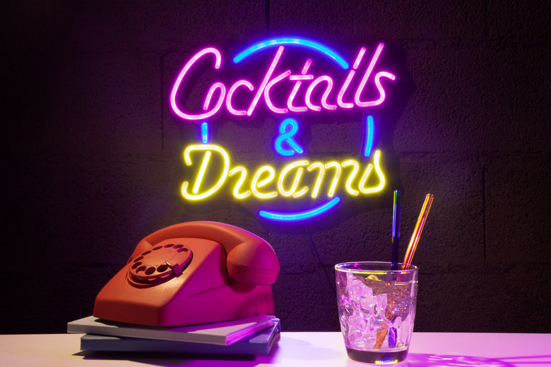 Cocktails and Dreams neon sign glowing on a home bar wall