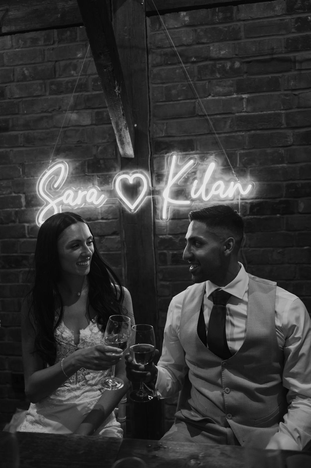 Personalised wedding neon sign lighting up a venue wall